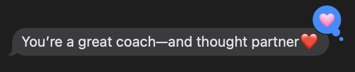 Regina Text Screenshot A screenshot of a text message bubble on a black screen reading "You're a great coach—and thought partner" followed by a red heart emoji.